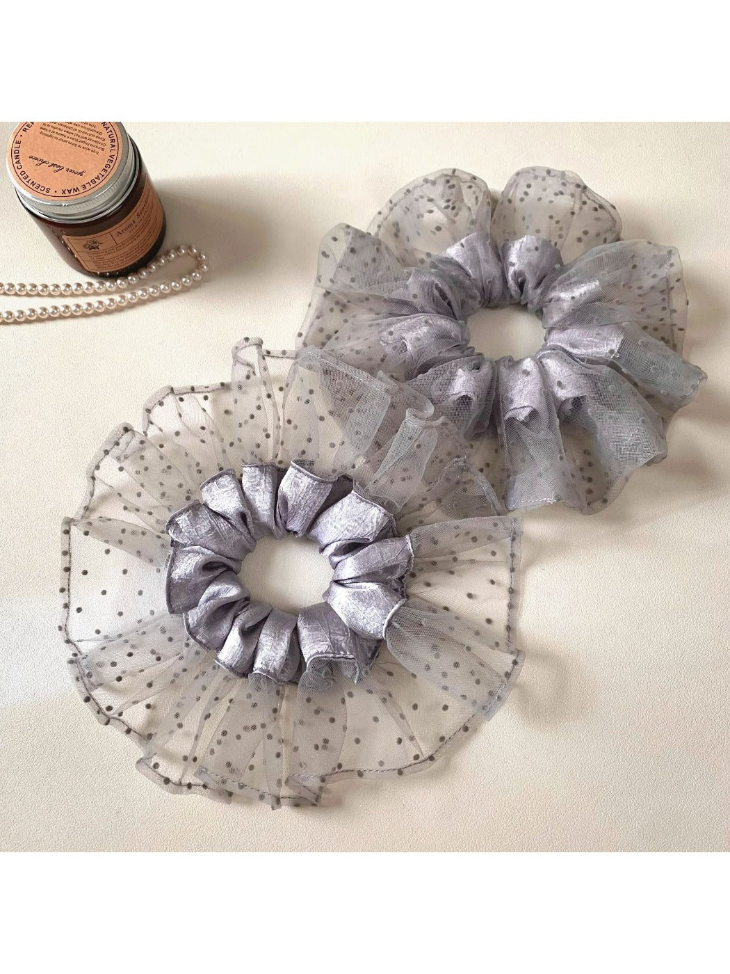 Close-up of gray mesh fabric with black polka dots on scrunchie