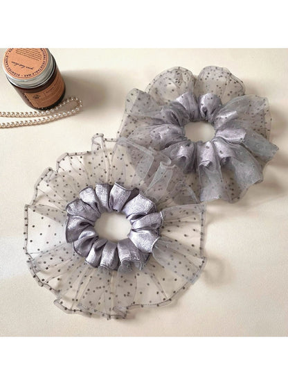 Close-up of gray mesh fabric with black polka dots on scrunchie
