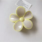 Beau flower shaped claw clip open to show inner clasp and hinge details