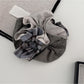 Gifty scrunchie displayed flat on white background highlighting fabric sheen