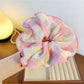 Gifty ruffled scrunchie in bright colors placed next to a small gift box