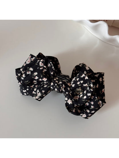 Beau small bow hair clip with pink floral pattern styled in hair