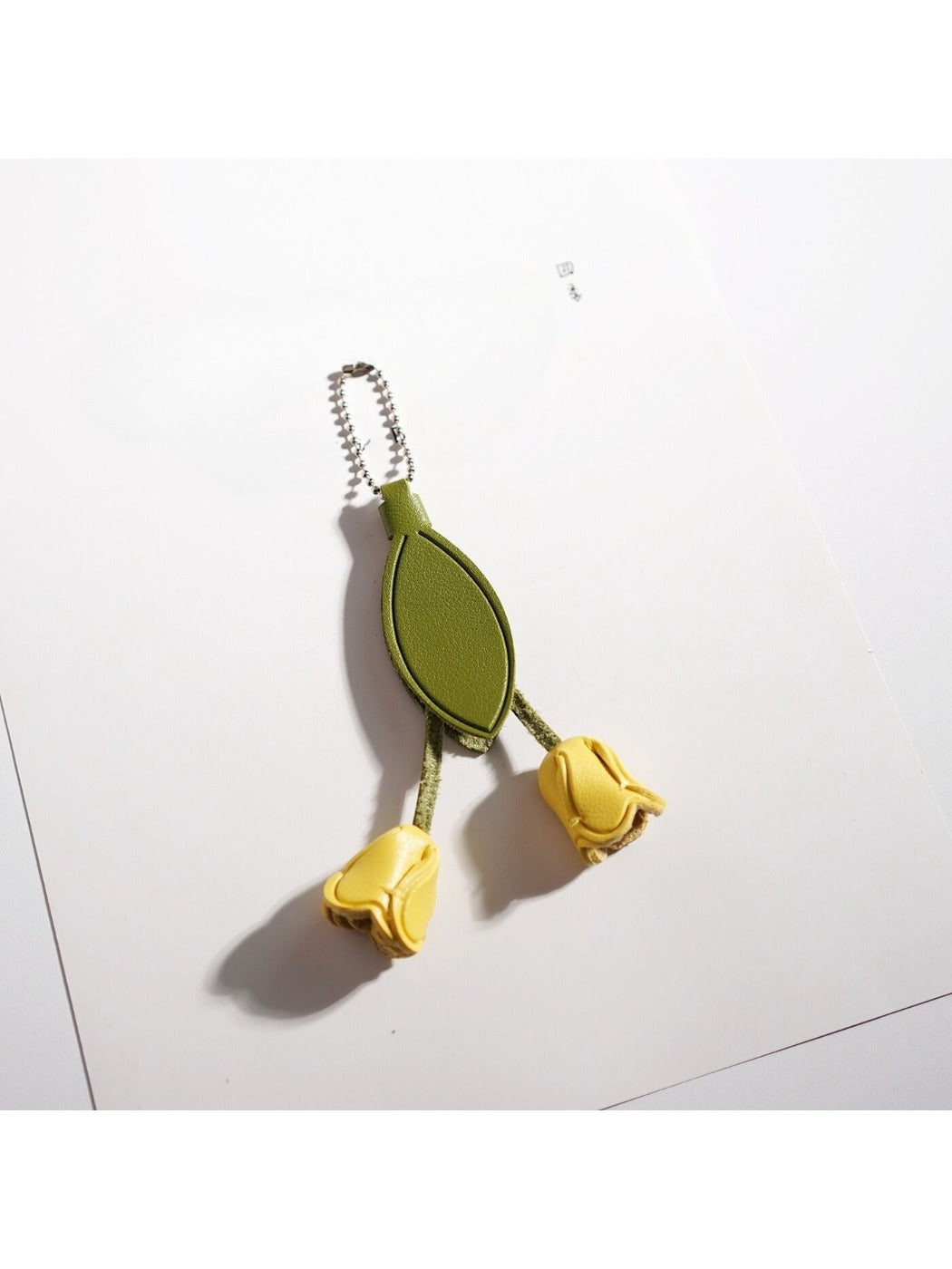 Hand holding the tulip flower shaped keychain with a blurred background