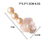 Beau Camellia beaded hair clip held in hand displaying size and shape