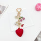 Cherry heart charm keychain hanging from a gold keyring with a soft shadow