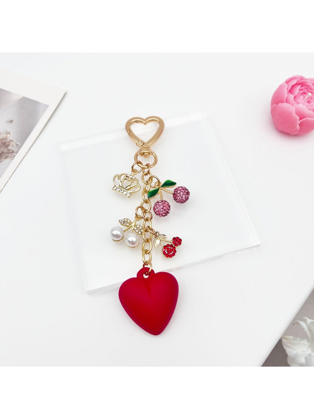 Cherry heart charm keychain hanging from a gold keyring with a soft shadow