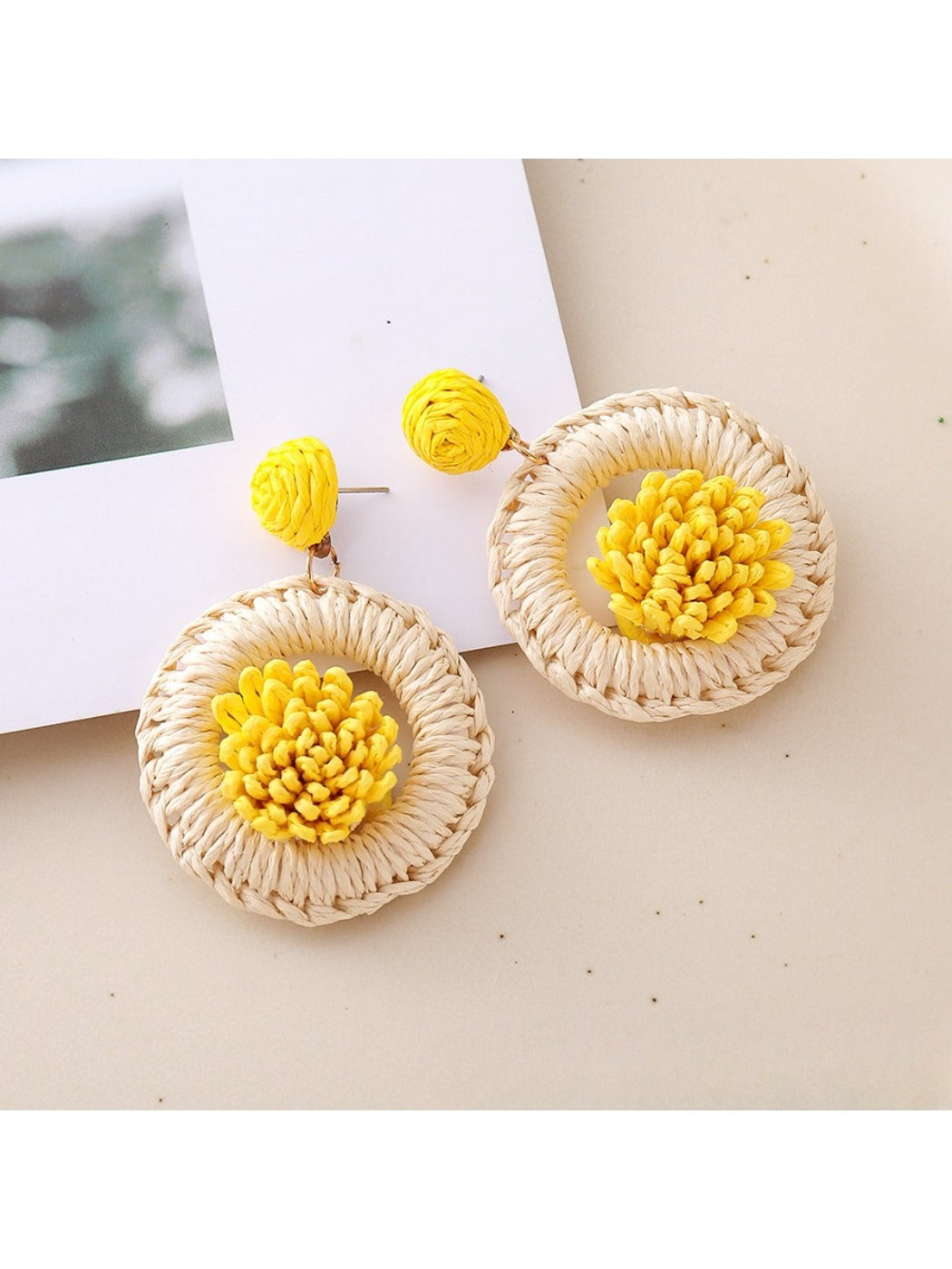 Earedge raffia earrings styled with casual outfit on a wooden surface