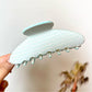 Beau polka dot acetate claw clip worn in long hair from back view