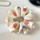 Gifty Lazy Style scrunchie with white polka dots on a light pink fabric