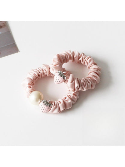 Close-up of a cute strawberry decorated hair tie with red and green colors
