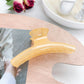 Pastel curved claw clip displayed alongside matching pastel hair accessories