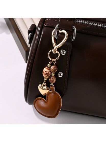 Brown heart-shaped leather keychain with metal ring on white background