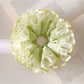 Close-up of light green ruffle scrunchie showing texture and fabric folds