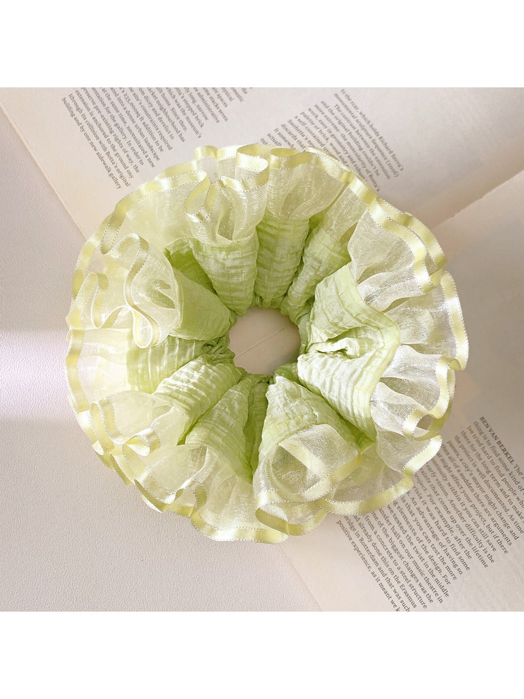 Close-up of light green ruffle scrunchie showing texture and fabric folds