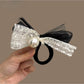 Black elastic hair tie with a classic satin bow adorned with tiny pearl details