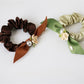 Gifty floral hair tie wrapped around a ponytail on a model with brown hair