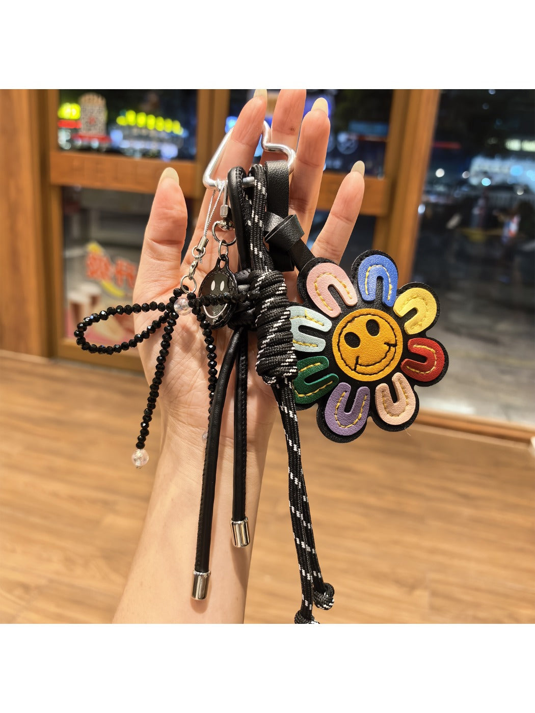 Rainbow sunflower shaped keychain with vibrant multicolor petals and a gold keyring
