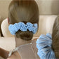 Solid color satin scrunchie showing gathered ruched fabric detail