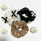 Close-up of Gifty satin bow embellished lace scrunchie in soft pink