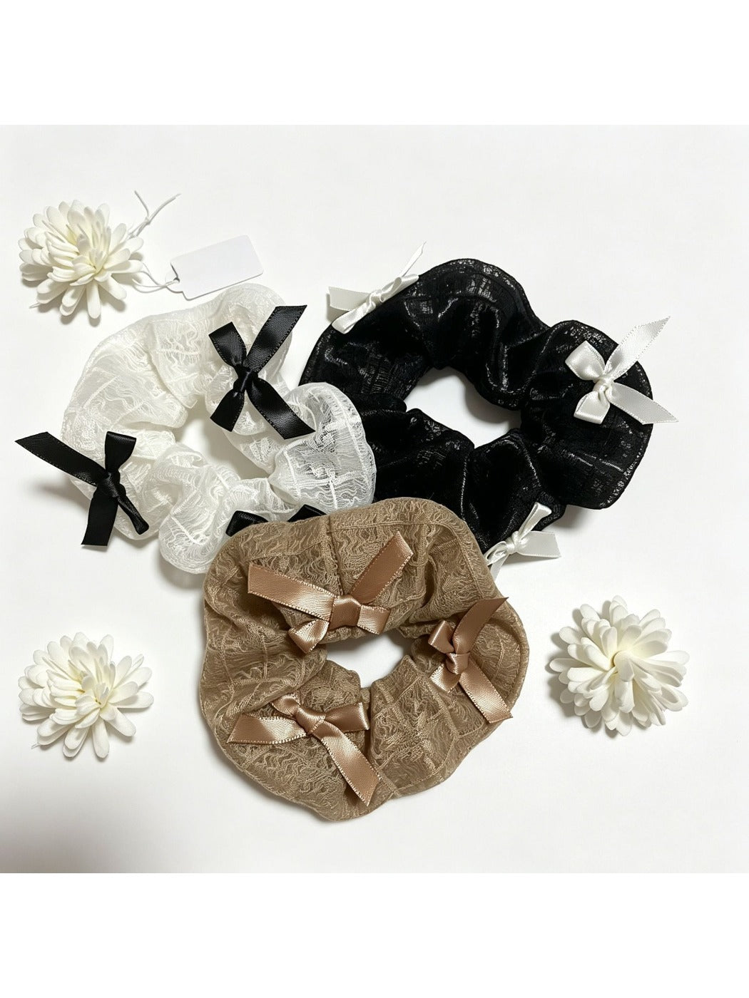 Close-up of Gifty satin bow embellished lace scrunchie in soft pink