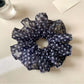 Gifty scrunchie packaging with retro floral design and brand label