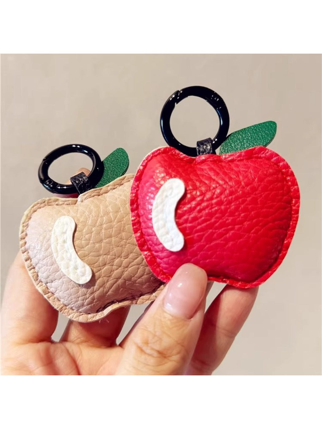 Apple keychain attached to a set of keys on a wooden surface