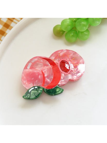 Orange fruit hair clip paired with casual outfit on a wooden table