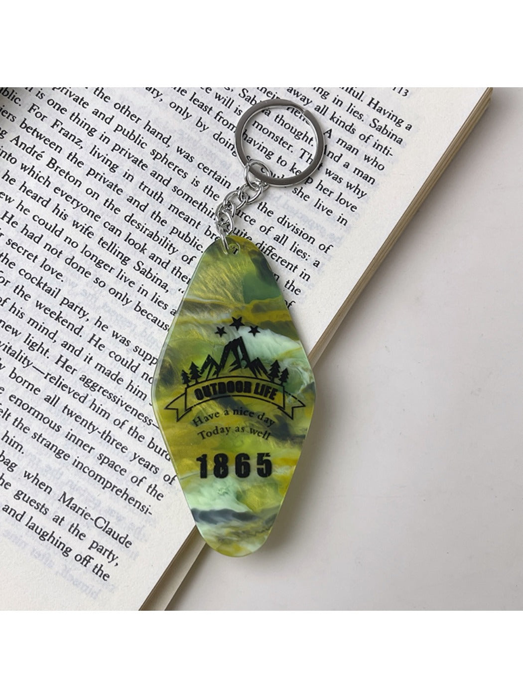 Diamond-shaped pendant keychain displayed on a wooden surface with natural light