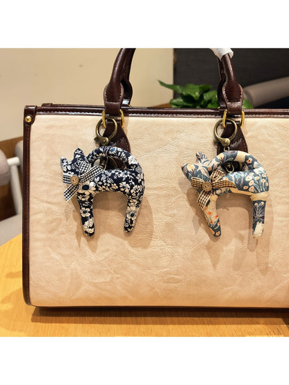 Side view of Keypus cartoon cat charm keychain showing its rounded shape and metal keyring