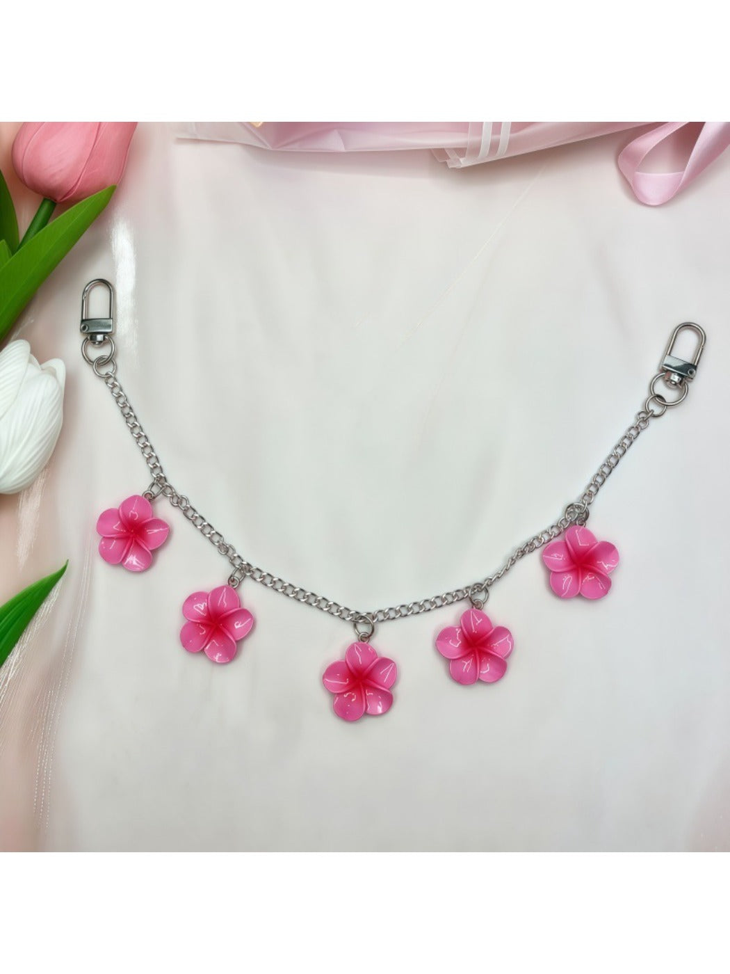 Minimalist flower pendant bag charm styled with casual handbag