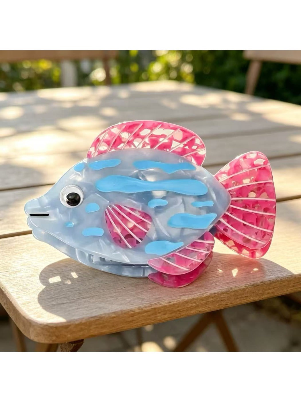 Beau claw clip held in hand to show scale and sea animal shape