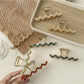 Side view of Beau wavy metal claw clip highlighting metal texture