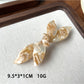 Beau bow shaped updo hair clip in beige shown with other hair accessories