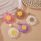 Close-up of vintage raffia woven sunflower earring with yellow petals and brown center