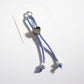 Keychain heart made of multicolored ropes with a metal ring on a wooden surface