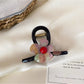Beau flower claw clip resting on white surface with soft shadows