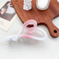 Beau heart shaped bow claw clip in ombre gradient resting on a pastel colored fabric