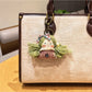 Vintage girl charm keychain placed on a fabric surface with soft lighting