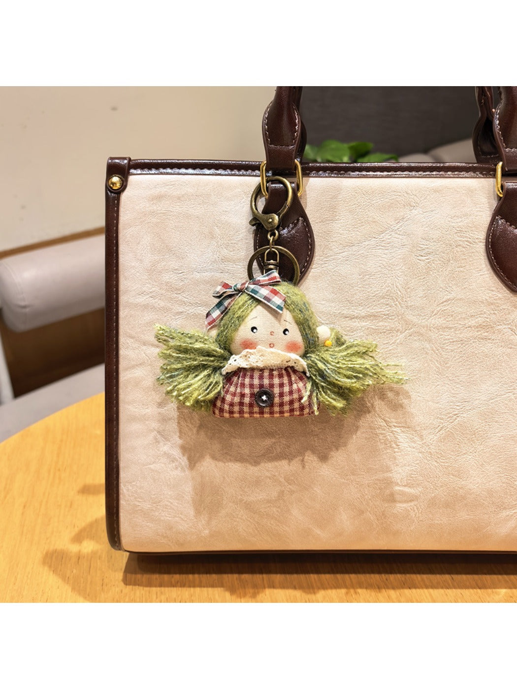 Vintage girl charm keychain placed on a fabric surface with soft lighting