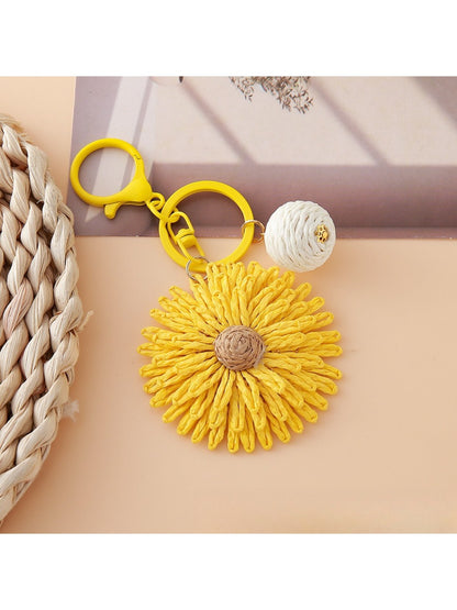 Sunflower keychain attached to a set of keys on a wooden surface