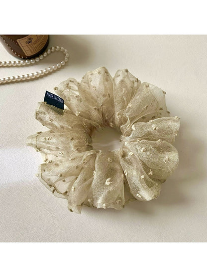Khaki mesh scrunchie with white polka dots on a white background