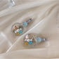 Beau hair clip featuring a large conch shell decoration on a gold-toned base