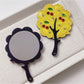 Mirroray handheld mirror with unique tree design shown from above