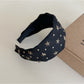 Gifty personalized headband worn on a mannequin head with star decorations