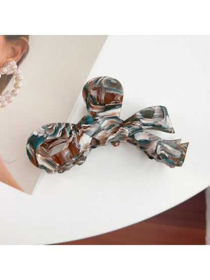 Beau delicate bow hair claw clip displayed on a wooden surface
