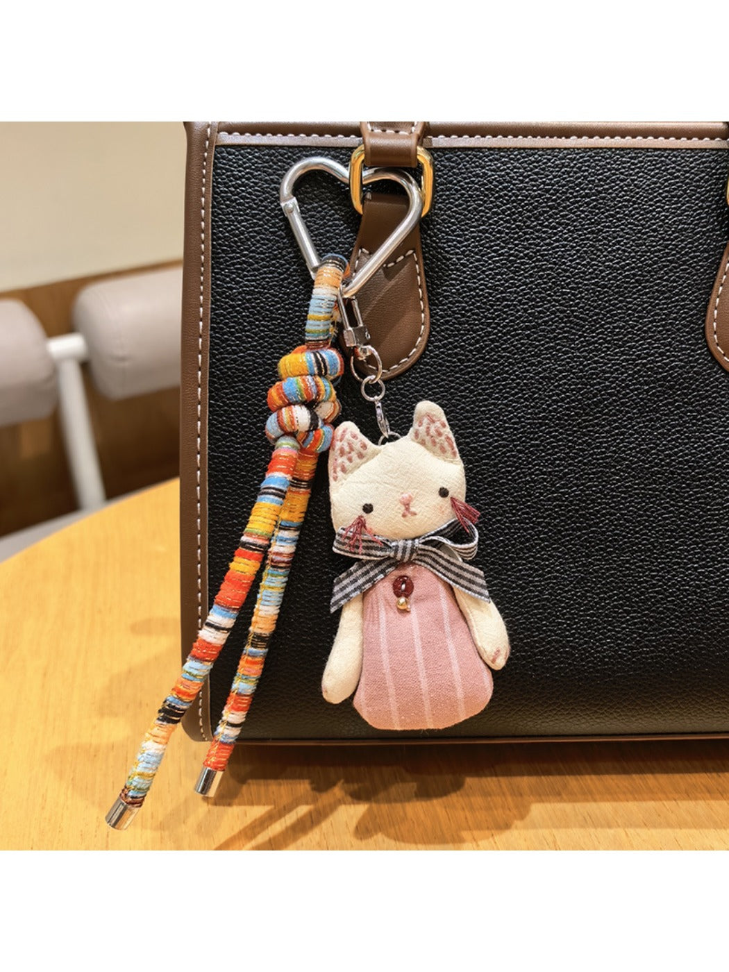 Cat charm keychain hanging from a backpack zipper pull