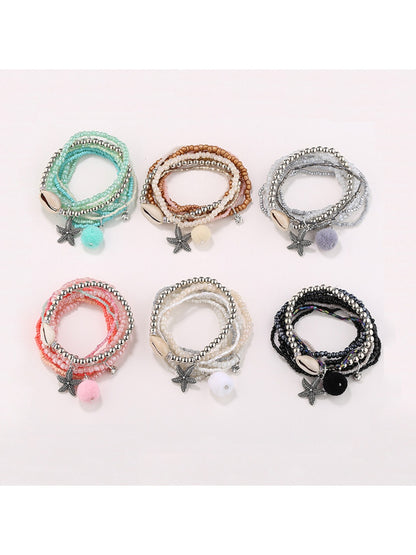 Lovra multi-row small bead bracelet with gold and silver beads on a white background
