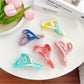 Beau color blocked heart shaped claw clip in pastel pink and beige on white background