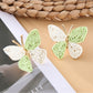 Butterfly drop earrings displayed with matching silver necklace on a white surface