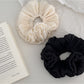 Gifty shimmer scrunchie showing layered fabric texture and elastic band